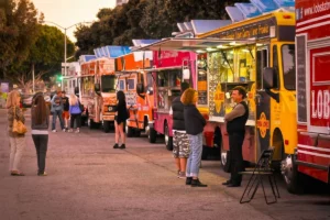 Colorful food trucks with crowds at a vibrant street food market