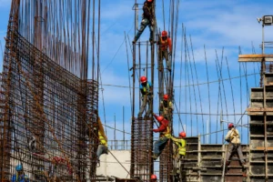 Construction workers installing steel reinforcement bars on an active commercial building construction site