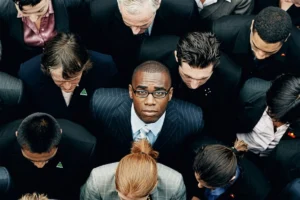 A man looking upward while surrounded by a crowd