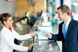 Airline staff assisting a passenger at the airport check-in counter.