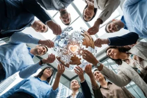 Collaborative workforce forming a circle while connecting puzzle pieces