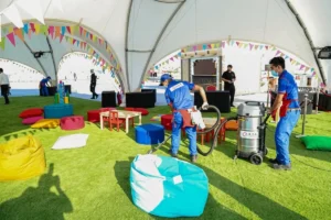 Cleaning crew vacuuming synthetic grass at a commercial outdoor space