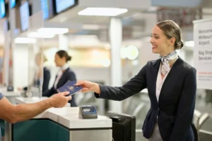 Flight attendant receiving a traveler's passport before boarding.