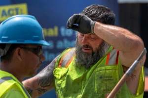 Hardworking construction worker wiping sweat on the job