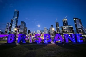 Large Brisbane sign in a park with the city skyline at night