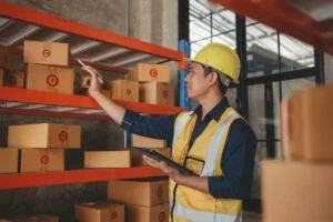 Logistics worker checking product labels on storage boxes.