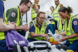 Medical staff performing a patient care procedure in a clinical setting.
