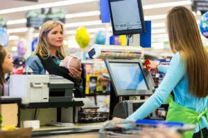Mother with her baby waiting to complete a grocery checkout.