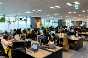 Office employees working on computers in a modern workplace.