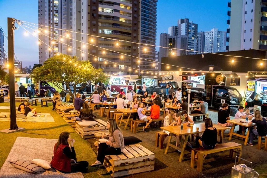 Outdoor restaurant at night with illuminated dining area.