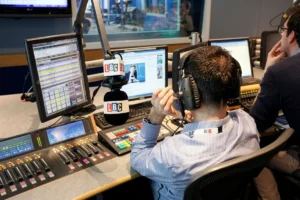 Podcast technician monitoring sound quality in a professional recording studio.