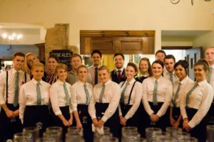 Restaurant servers smiling together in their uniforms.