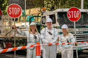 Road construction crew wearing PPE directing traffic with a stop sign.