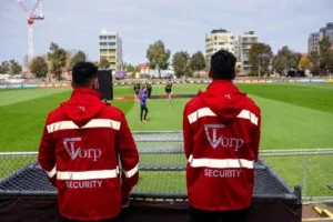 Security guard observing the football field to ensure public safety.
