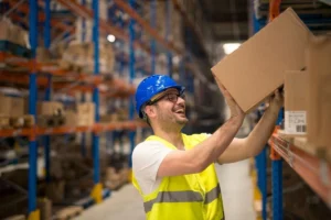 Smiling worker
organizing boxes on warehouse storage shelves