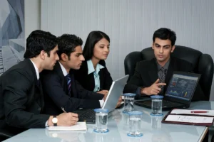 Supervisor analyzing printed graphs while discussing results with an employee.