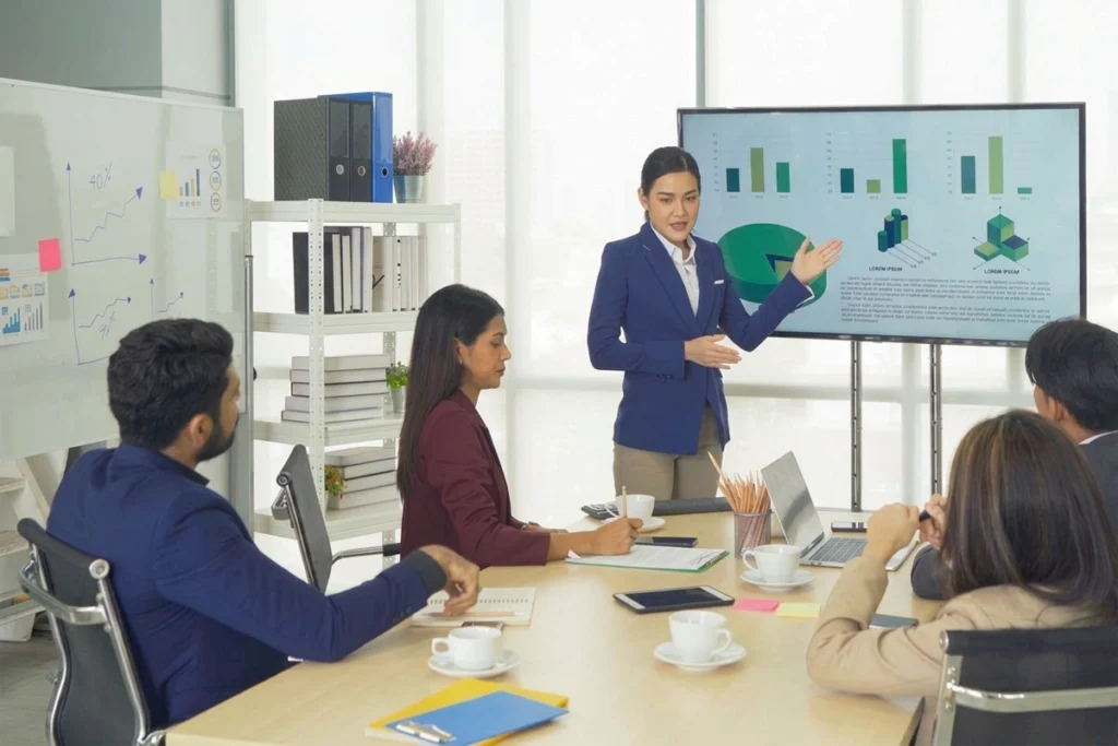 Supervisor and employee discussing performance reports and printed graphs.