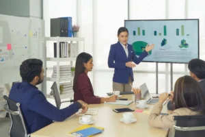 Supervisor and employee discussing performance reports and printed graphs.