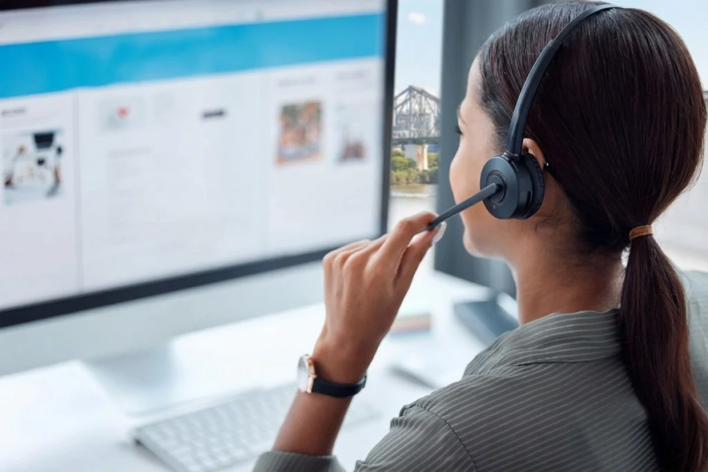 Support agent holding headset microphone while assisting customers