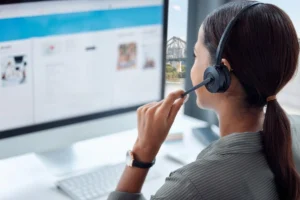 Support agent holding headset microphone while assisting customers