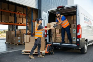 Two warehouse employees transferring a box during package handling.