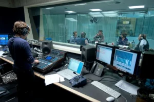 Woman monitoring audio levels in a podcast recording studio.