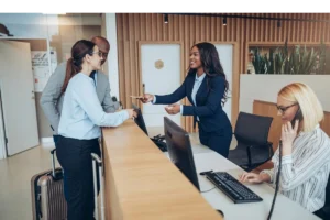 Female staff giving a room key card to a guest during check-in.