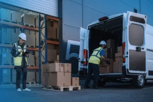Warehouse workers unloading packages from a truck while checking a delivery checklist.