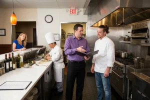 Head chef and supervisor discussing kitchen operations.