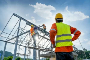 Construction workers fixing a roof frame as a foreman looks up.