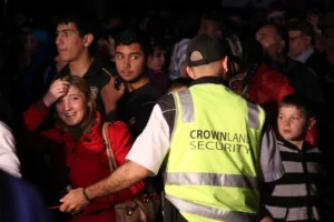 Security personnel guiding people along a designated pathway.