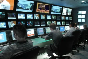 Staff observing a monitoring system from a control room.