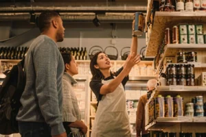 Supermarket staff assisting a customer with selecting grocery products.