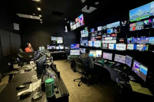 Two IT professionals monitoring network systems in a control room.