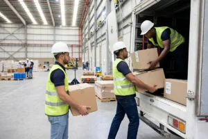 Three workers loading boxes into a courier delivery vehicle.